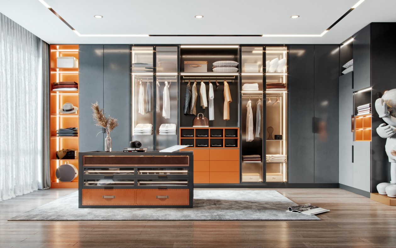 Modern walk-in closet with orange accents, clothing, and central island.